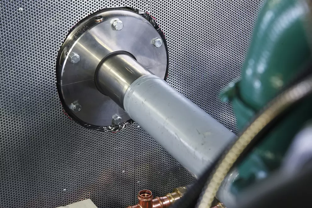 Shaft sealing assembly installed through protective equipment housing.