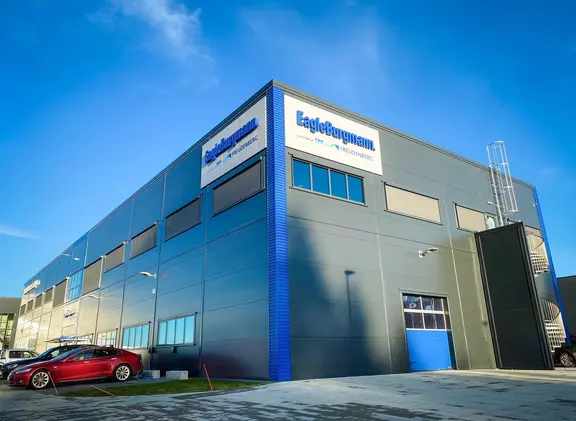 Moderne kontor- og industribygg fra EagleBurgmann med firmaskilt under en klar blå himmel.