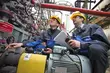 Two EagleBurgmann service technicians inspecting industrial equipment at a plant site, wearing safety helmets and protective clothing while performing technical field service and maintenance checks.