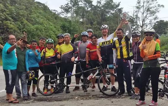 EagleBurgmann Malaysia employees and visually impaired participants posing with tandem bicycles during a community cycling event promoting inclusion and teamwork.