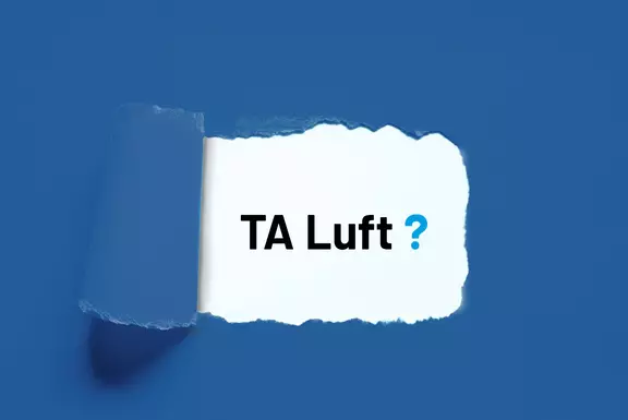 Papierabriss-Grafik mit dem Text „TA Luft?“ auf blauem Hintergrund, passend für Inhalte zu Luftreinhaltung, Emissionsvorgaben oder Umweltvorschriften.