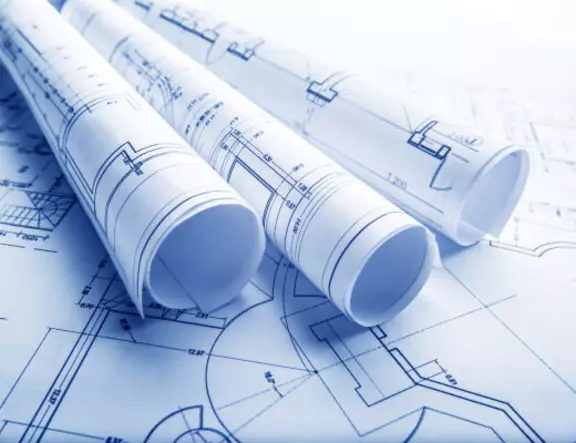 Rolled architectural blueprints and technical drawings for a construction project.