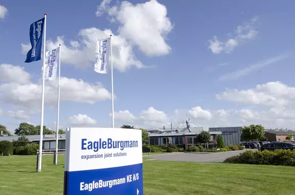 EagleBurgmann KE A/S facility in Denmark with company sign, flags, and office building exterior, highlighting the site presence and corporate identity.