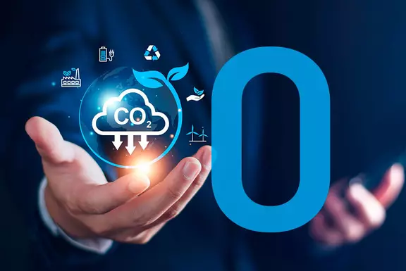 Businessperson holding a CO₂ reduction icon, symbolizing carbon neutrality and sustainable innovation.