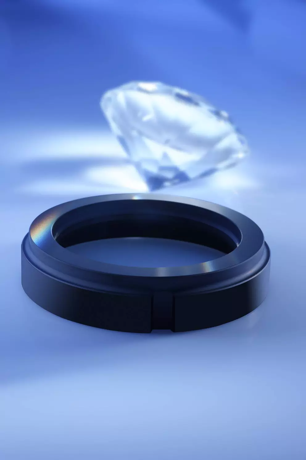 A dark, ring-shaped component, possibly a seal or bearing ring, in the foreground with a large, faceted diamond blurred in the background, set against a blue gradient.