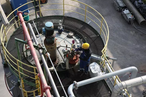 Technician performing maintenance on an industrial process plant, viewed from above.