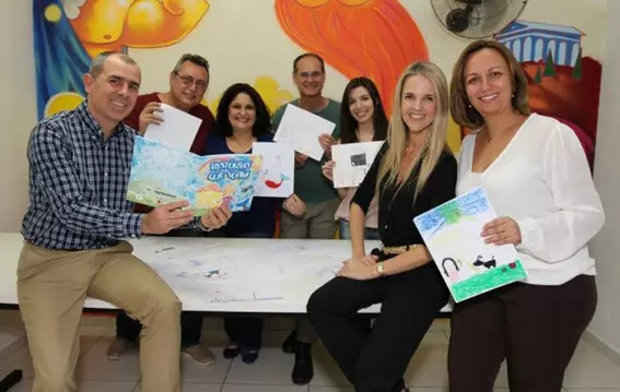 EagleBurgmann Brazil team presenting children’s drawings from the ‘Told Stories’ project at Centro Infantil Boldini, supporting young cancer patients through art and storytelling.