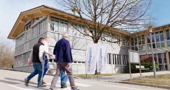 Team members in front of the company building on their way to the entrance.