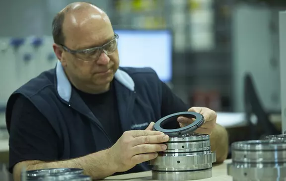 Technician inspecting the fit of a precision bearing ring during assembly.