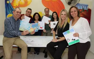 EagleBurgmann Brazil team presenting children’s drawings from the ‘Told Stories’ project at Centro Infantil Boldini, supporting young cancer patients through art and storytelling.