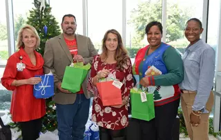 EagleBurgmann USA employees delivering holiday gift bags to support students at a Houston elementary school as part of ongoing community and education programs.
