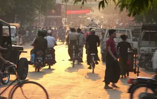 Busy street in Indonesia with motorcycles and bicycles, illustrating EagleBurgmann’s safety initiative providing helmets to employees to prevent head injuries in traffic accidents.