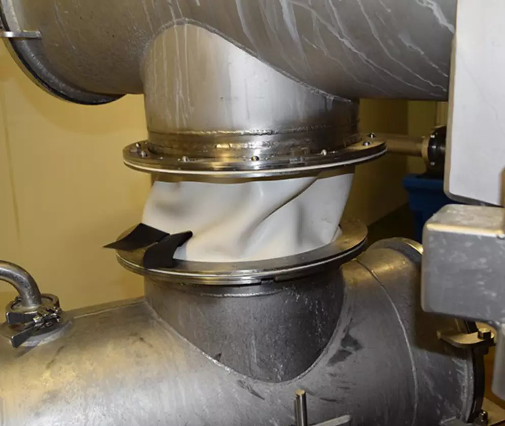 Flexible hygienic pipe connection with stainless steel fittings used in food or pharmaceutical processing.