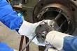 Technicians wearing protective gloves assembling or disassembling an industrial mechanical seal on a large machine.