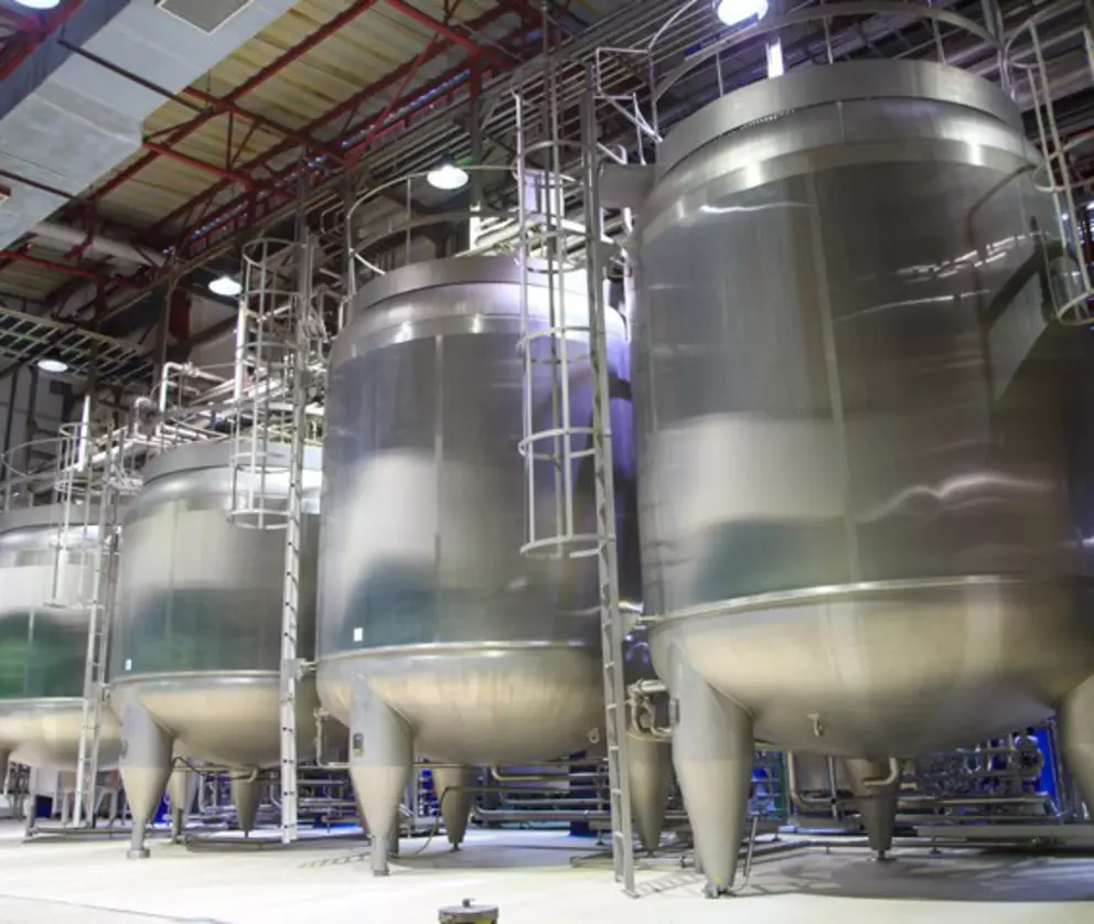 Stainless steel industrial storage tanks used in food, beverage, or pharmaceutical production facilities.