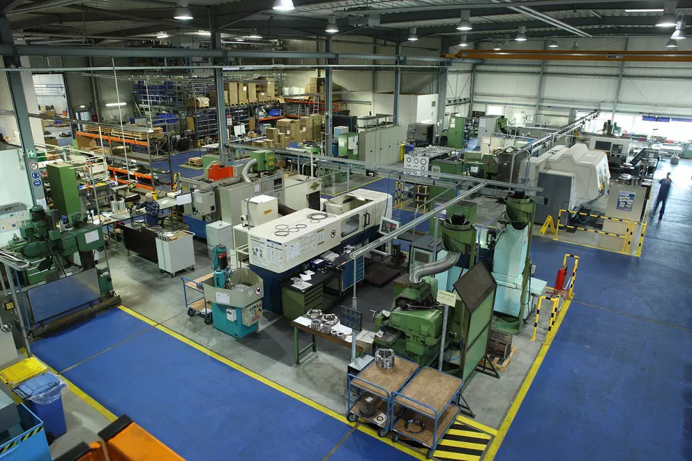 Overview of an industrial manufacturing hall with CNC machines and production equipment.