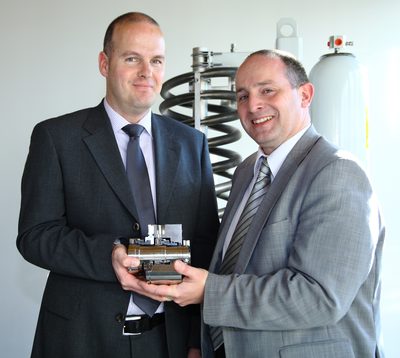 The EagleBurgmann API specialists Markus Fries and Thomas Böhm (from left to right) with a new developed API mechanical seal and the corresponding seal supply system according to API Plan 53B.